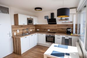 a kitchen with white cabinets and a sink at Ferienapartment Seeblick in Meersburg