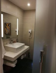 un bagno con un lavandino bianco e uno specchio di SG - AA Hotel ad Abuja