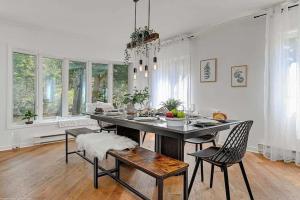 una sala da pranzo con tavolo, sedie e finestre di Beau chalet bord de rivière et spa, Beautiful riverside cottage! a Saint Come