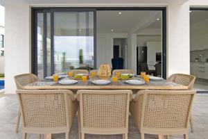 een eettafel met stoelen en eten erop bij Villa Amity in Protaras