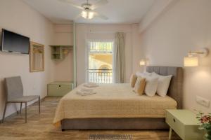 a bedroom with a large bed and a window at Pension Omorfi Poli in Nafplio