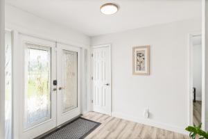 a white hallway with white walls and doors and a rug at Gulf Breeze Haven Direct Gulf Access Pool+Dock in Cape Coral