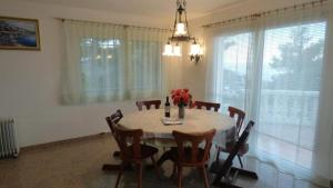 a dining room with a table and chairs with flowers on it at Casa Dorada in Roses +7 photos