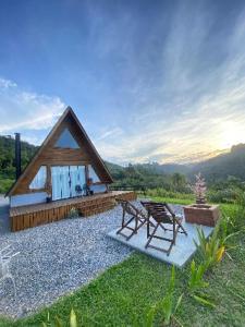 a cabin with two chairs sitting in front of it at Chalé águas Frias in Alfredo Wagner
