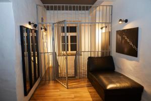 a living room with a leather couch and a window at BDSM Black Apartments in Vilnius