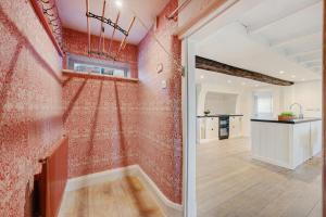 une pièce vide avec des murs rouges et un couloir dans l'établissement Wheelwrights Cottage, à Tarporley
