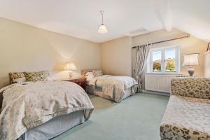 une chambre avec deux lits et une fenêtre dans l'établissement Wheelwrights Cottage, à Tarporley