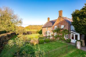 une grande maison en briques avec une cour dans l'établissement Wheelwrights Cottage, à Tarporley