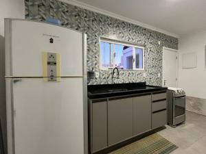 a kitchen with a refrigerator and a sink at Cuxipa House in Sao Paulo +1 photo