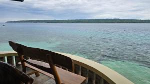 a chair sitting on a dock near the water at Lydias House kaputian samal in Kaputian