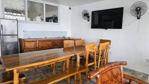 a dining room with a wooden table and a refrigerator at Lydias House kaputian samal in Kaputian