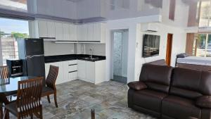 a kitchen and living room with a couch and a table at Lydias House samal kaputian in Kaputian +18 photos