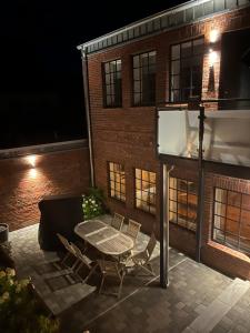 a patio with a table and chairs in front of a building at Loftwohnung 1 Simmerdeis an der Gracht in Friedrichstadt