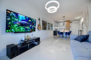 a living room with a blue couch and a flat screen tv at Apartment Lipotica 1 in Nin