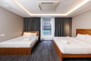 a hotel room with two beds and a window at The Bed Bukit Bintang in Kuala Lumpur +68 photos