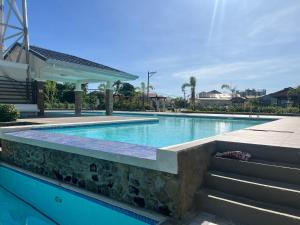 a swimming pool with a stone retaining wall and stairs at Comfort Zone in Dao