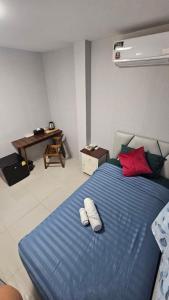 a bedroom with a blue bed with red pillows at แกร็บสลีปโฮสเทล แอร์พอร์ตดอนเมือง in Ban Ko