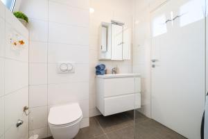 a white bathroom with a toilet and a sink at Apartment Lipotica 1 in Nin +17 photos
