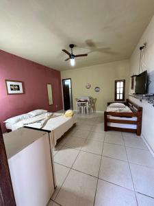 a large room with two beds and a kitchen at Suites do Peró in Cabo Frio