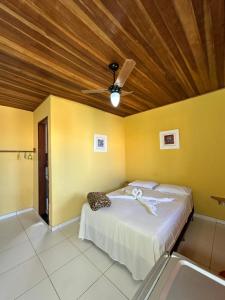 a bedroom with a bed and a ceiling fan at Suites do Peró in Cabo Frio