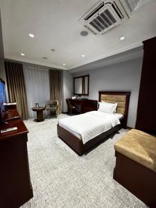 a hotel room with a bed and a desk at Mir Luxe Plaza in Tashkent