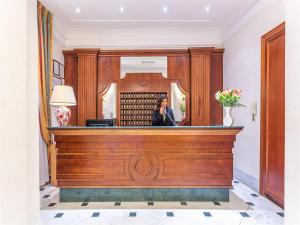 a woman talking on a phone in a courtroom at Raeli Hotel Lux in Rome