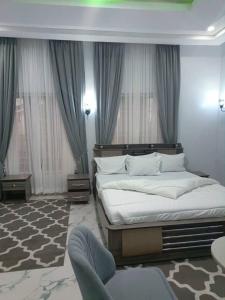JosSoda Hotels And Resorts Rantya Jos Delux Exclusive Suite的带一张大床和一把椅子的卧室