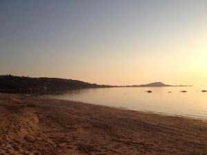 a view of the beach at sunset at Hotel l'Isolella in Porticcio