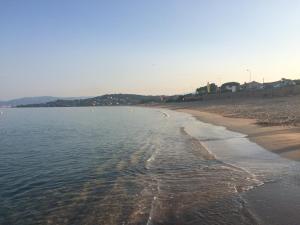 a beach with a shoreline and the ocean at Hotel l'Isolella in Porticcio