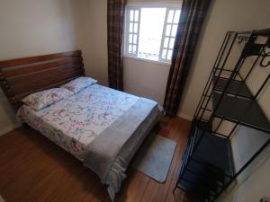 sypialnia z łóżkiem i oknem w obiekcie Casa Campos w mieście São Lourenço