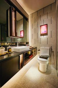 a bathroom with a white toilet and a sink at Scarletz Suites KLCC by M Suites in Kuala Lumpur