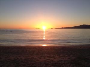 a sunset on the beach with the sun setting at Hotel l'Isolella in Porticcio