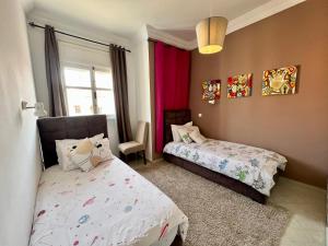 a bedroom with two beds and a window at Appartement jade in Essaouira