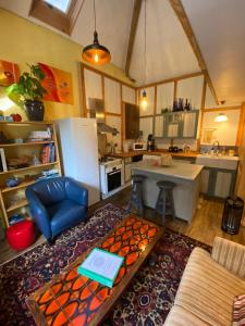 a kitchen with a refrigerator and a table in a room at Loft Apartment at Moulin SAGE in Treignac