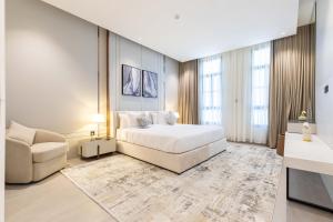 リヤドにあるAmber Hospitality - BLVDのベッドとソファと椅子のある寝室