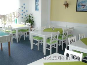 a dining room with white tables and white chairs at Ski und Biker Hotel Villa Sonnenschein Braunlage am Wurmberg in Braunlage