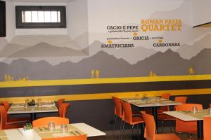 a restaurant with tables and chairs and a wall with a mountain mural at Roma Scout Center in Rome