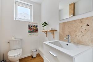 a white bathroom with a toilet and a sink at La Tourelle de Saint Michel de Livet - Parking in Livarot