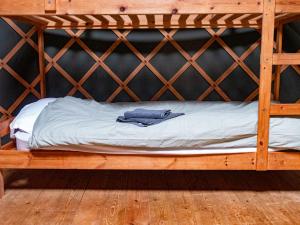 a wooden bunk bed with a pair of jeans on it at Yurt Room Two in Talaton