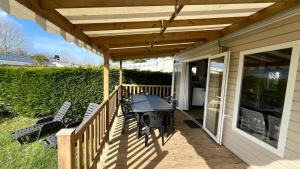 a wooden deck with a table and chairs on it at Mobilhome Ile d'Oléron - 6 places - Camping 5 étoiles in Saint-Georges-dʼOléron