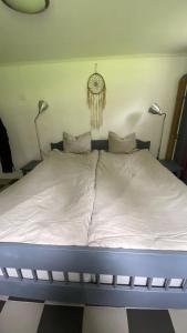 a bed in a room with two lights on the wall at Forest Seaside living in Vallda Kattegatt trail in Vallda