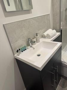 ハルにあるCosy Executive City Apartment 3の白い洗面台と鏡のあるバスルーム