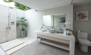 a bathroom with a sink and a toilet and a mirror at Living Asia Resort and Spa in Senggigi