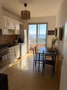 cocina con mesa y sillas y comedor en Appartement Bastia vue mer - 2 chambres, en Bastia