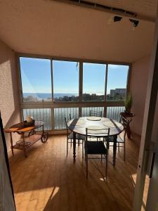 Una habitación con una mesa y sillas y una ventana grande. en Appartement Bastia vue mer - 2 chambres, en Bastia