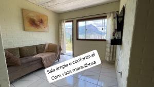 un salon avec un canapé et une fenêtre dans l'établissement Flat com vista espetacular área central-cozinha completa-AR- 2 banheiros- casais - grupos ou familias ou empresas, à Governador Valadares 11 autres photos