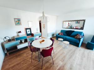 ein Wohnzimmer mit einem Tisch und einem blauen Sofa in der Unterkunft Appartement T2 Bord de Mer - Maria Beach in Santa-Lucia-di-Moriani