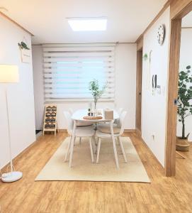 a dining room with a white table and chairs at Yun Stay Seongsu in Seoul