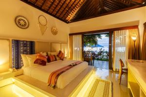 a bedroom with a bed with a view of the ocean at Living Asia Resort and Spa in Senggigi