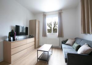 a living room with a couch and a tv at Cozy et bien équipé près de Paris in Saint-Maur-des-Fossés